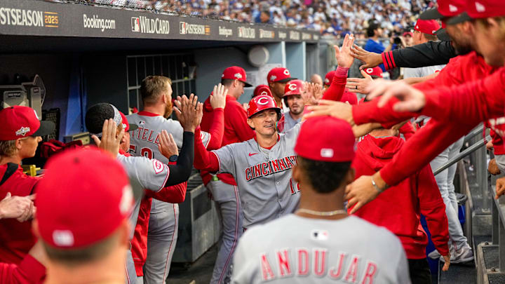 Cincinnati Reds right fielder Austin Hays (12) celebrates after scoring on a two-RBI single off the bat of third baseman Sal Stewart (43) in the first inning of the MLB National League Wild Card Game 2 between the Los Angeles Dodgers and the Cincinnati Reds at Dodger Stadium in Los Angeles on Wednesday, Oct. 1, 2025. The Reds were eliminated from the postseason with an 8-4 loss to the reining World Series Champions La Dodgers.