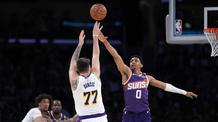 Mar 16, 2025; Los Angeles, California, USA; Los Angeles Lakers guard Luka Doncic (77) shoots the ball against Phoenix Suns forward Ryan Dunn (0) in the second half at Crypto.com Arena. Mandatory Credit: Kirby Lee-Imagn Images