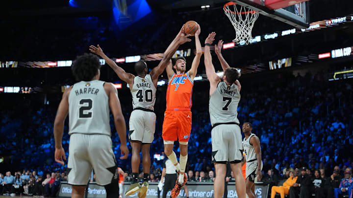Dec 13, 2025; Las Vegas, Nevada, USA; Oklahoma City Thunder center Chet Holmgren (7) shoots over San Antonio Spurs forward Harrison Barnes (40) and center Luke Kornet (7) during the first quarter at T-Mobile Arena. Mandatory Credit: Kirby Lee-Imagn Images Dec 13, 2025; Las Vegas, Nevada, USA; Oklahoma City Thunder center Chet Holmgren (7) shoots over San Antonio Spurs forward Harrison Barnes (40) and center Luke Kornet (7) during the first quarter at T-Mobile Arena. Mandatory Credit: Kirby Lee-Imagn Images