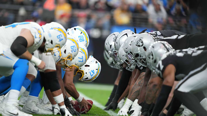 Jan 5, 2025; Paradise, Nevada, USA; Helmets at the line of scrimmage as Los Angeles Chargers long snapper Josh Harris (47) snaps the ball against the Las Vegas Raiders at Allegiant Stadium. Mandatory Credit: Kirby Lee-Imagn Images