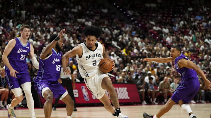 Jul 14, 2025; Las Vegas, NV, USA; San Antonio Spurs guard Dylan Harper drives the ball past Utah Jazz guard Elijah Harkless (16) during the second half in a NBA basketball game at the Thomas & Mack Center. Mandatory Credit: Lucas Peltier-Imagn Images