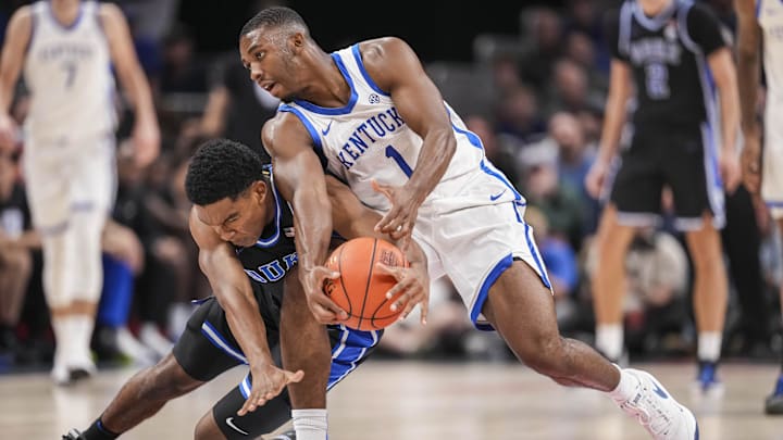 Nov 12, 2024; Atlanta, Georgia, USA; Duke Blue Devils guard Caleb Foster (1) and Kentucky Wildcats guard Lamont Butler (1) fight for a loose ball during the first half at State Farm Arena. Mandatory Credit: Dale Zanine-Imagn Images