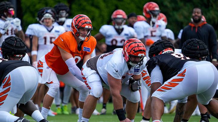 Cincinnati Bengals quarterback Joe Burrow (9) takes a snap from center Ted Karras (64) during practice at the Paycor Stadium practice facility in downtown Cincinnati on Monday, Aug. 3, 2026. Cincinnati Bengals quarterback Joe Burrow (9) takes a snap from center Ted Karras (64) during practice at the Paycor Stadium practice facility in downtown Cincinnati on Monday, Aug. 3, 2026.