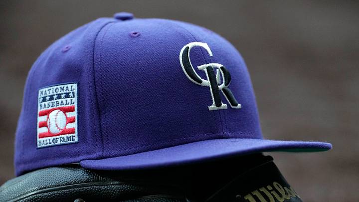 Colorado Rockies hat on top of a glove Colorado Rockies hat on top of a glove