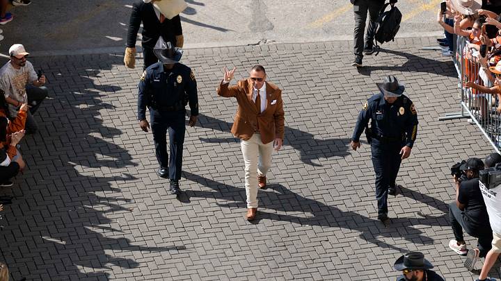 Texas Longhorns head coach Steve Sarkisian acknowledges fans by holding up his horns when entering Darrell K Royal-Texas Memorial Stadium alongside Police Texas Longhorns head coach Steve Sarkisian acknowledges fans by holding up his horns when entering Darrell K Royal-Texas Memorial Stadium alongside Police