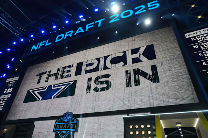 The Dallas Cowboys logo is projected on the video board during the NFL Draft at Lambeau Field.