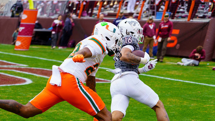 Nov 22, 2025; Blacksburg, Virginia, USA; Virginia Tech Hokies running back Jeffrey Overton (16) runs in for the touchdown against Miami (FL) Hurricanes defensive back Dylan Day (23) during the third quarter at Lane Stadium. Mandatory Credit: Neville E. Guard-Imagn Images