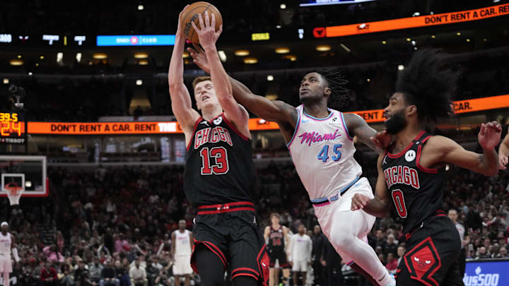 Apr 9, 2025; Chicago, Illinois, USA; Chicago Bulls guard Kevin Huerter (13) and Miami Heat guard Davion Mitchell (45) go for the ball during the second half at United Center. Mandatory Credit: David Banks-Imagn Images