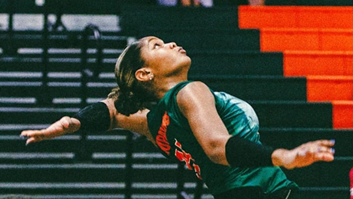 Grace Lopez spiking a ball against an opponent.
