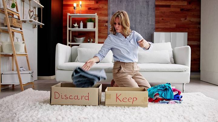 Woman in living room with boxes reading "dicard" and "keep" Woman in living room with boxes reading "dicard" and "keep"