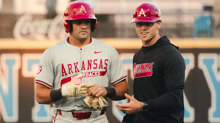 Arkansas catcher Ryder Helfrick sheds his gloves after driving in a run to make it 4-2 in the seventh against Kentucky.