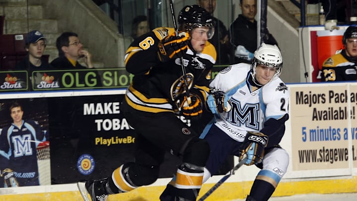 November 8, 2009; Mississauga, ON, CANADA; Kingston Frontenacs defenseman Erik Gudbranson (6) battles for the puck with Mississauga St. Michaels Majors forward forward Gregg Sutch (24) at the Hershey Centre. Mandatory Credit: John E. Sokolowski-Imagn Images