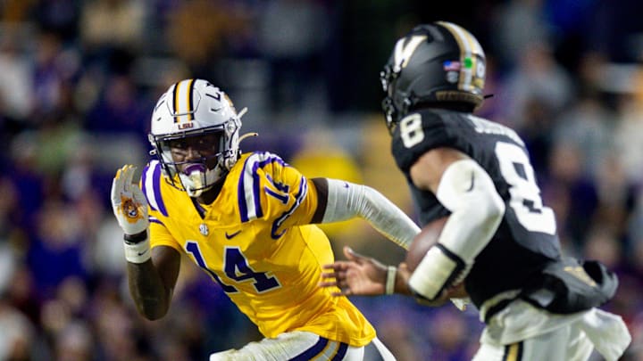 Nov 23, 2024; Baton Rouge, Louisiana, USA; LSU Tigers cornerback Zy Alexander (14) tackles Vanderbilt Commodores quarterback Nate Johnson (8) during the second half at Tiger Stadium. Mandatory Credit: Stephen Lew-Imagn Images Nov 23, 2024; Baton Rouge, Louisiana, USA; LSU Tigers cornerback Zy Alexander (14) tackles Vanderbilt Commodores quarterback Nate Johnson (8) during the second half at Tiger Stadium. Mandatory Credit: Stephen Lew-Imagn Images