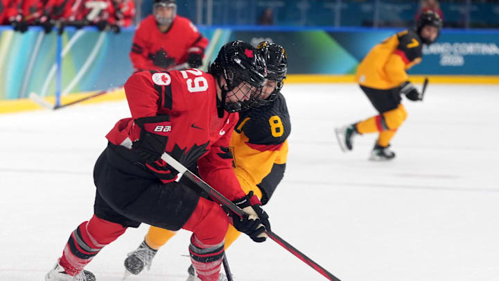 Feb 14, 2026; Milan, Italy; Marie-Philip Poulin of Canada in action with Ronja Hark of Germany in a women's ice hockey quarterfinal during the Milano Cortina 2026 Olympic Winter Games at Milano Rho Ice Hockey Arena. Mandatory Credit: Amber Searls-Imagn Images