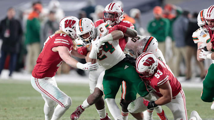 Dec 27, 2018; Bronx, NY, USA; Miami Hurricanes running back Travis Homer (24) is tackled by Wisconsin Badgers linebacker Andrew Van Ginkel (17) and linebacker T.J. Edwards (53) during the first half of the 2018 Pinstripe Bowl at Yankee Stadium.