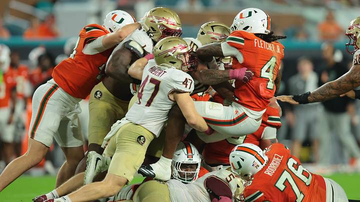 Oct 17, 2026; Miami Gardens, Florida, USA;  Miami Hurricanes running back Mark Fletcher Jr. (4) is tackled by Florida State Seminoles linebacker Chris Jones (10) and Florida State Seminoles defensive back Donny Hiebert (47) during the fourth quarter at Hard Rock Stadium.  Mandatory Credit: Sam Navarro-Imagn Images