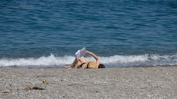 Woman reading on the beach in Greece
