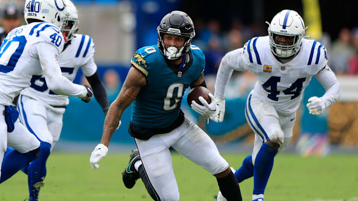 Jacksonville Jaguars wide receiver Gabe Davis (0) rushes for yards between Indianapolis Colts cornerback Jaylon Jones (40) and cornerback Chris Lammons (35) during the second quarter of an NFL football matchup Sunday, Oct. 6, 2024 at EverBank Stadium in Jacksonville, Fla. The Jaguars edged the Colts on a field goal 37-34. [Corey Perrine/Florida Times-Union]