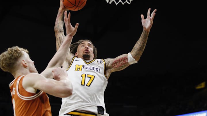 Feb 14, 2026; Columbia, Missouri, USA; Missouri Tigers guard Jayden Stone (17) goes up for a dunk over Texas center Matas Vokietaitis during the first half of a game at Mizzou Arena.