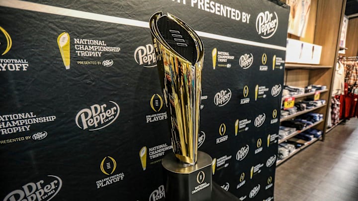 Fans stop to take photos with the College Football National Championship trophy at Meijer in Ypsilanti, Mich. on Thursday, Jan. 11, 2024. The trophy is going on a tour for fans to see presented by Dr. Pepper.