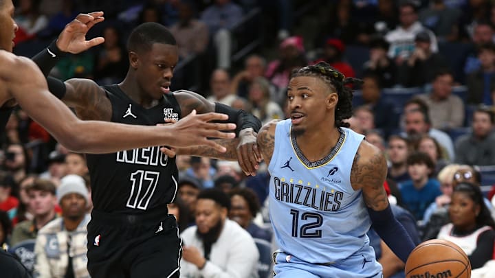 Dec 13, 2024; Memphis, Tennessee, USA; Memphis Grizzlies guard Ja Morant (12) drives to the basket as Brooklyn Nets guard Dennis Schroder (17) defends during the fourth quarter at FedExForum. Mandatory Credit: Petre Thomas-Imagn Images