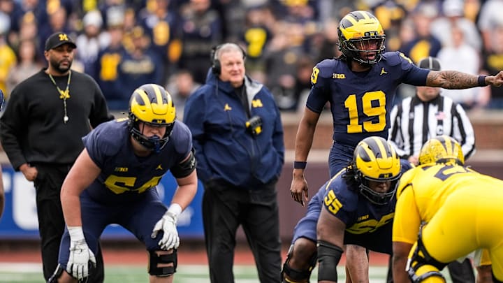 Michigan head coach Sherrone Moore, left, and associate head coach Biff Poggi watch quarterback Bryce Underwood (19)