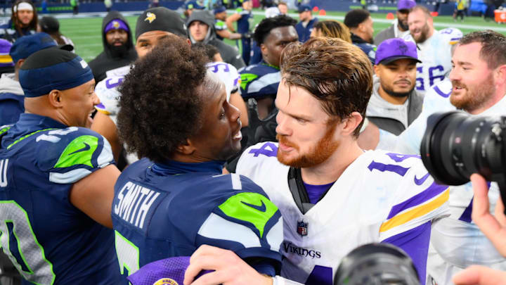 Dec 22, 2024; Seattle, Washington, USA; Seattle Seahawks quarterback Geno Smith (7) and Minnesota Vikings quarterback Sam Darnold (14) hug after the game at Lumen Field. Mandatory Credit: Steven Bisig-Imagn Images