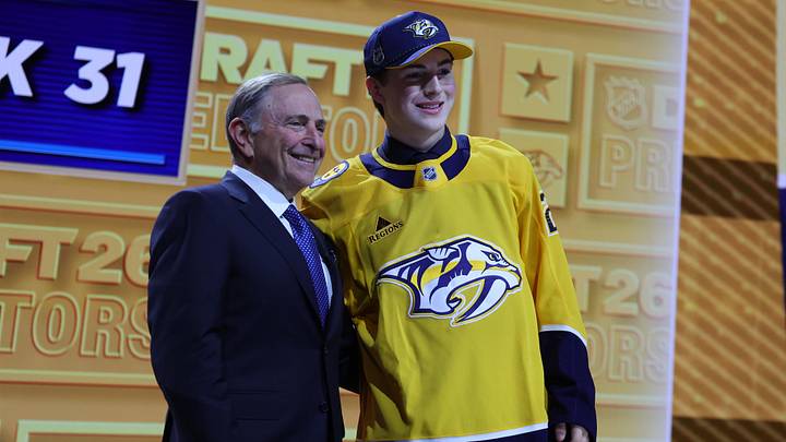 Jun 26, 2026; Buffalo, New York, USA; Tommy Bleyl reacts beside NHL commissioner Gary Bettman after being selected with the thirty first pick in the first round of the 2026 NHL Draft by the Nashville Predators at KeyBank Center. Mandatory Credit: Timothy T. Ludwig-Imagn Images