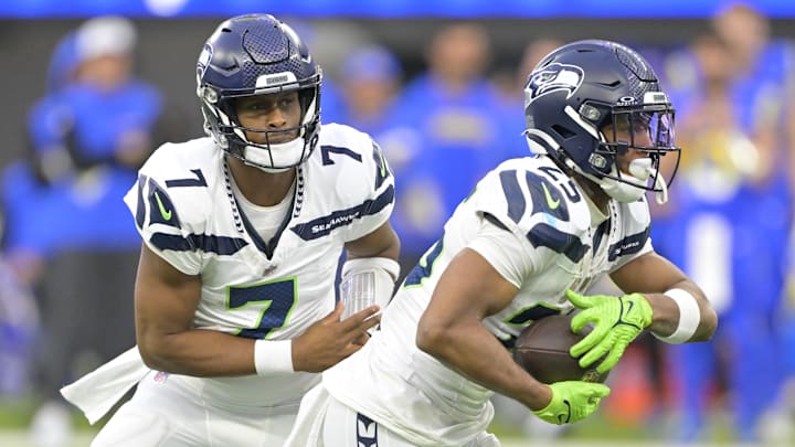 Jan 5, 2025; Inglewood, California, USA; Seattle Seahawks quarterback Geno Smith (7) hands off to running back Kenny McIntosh (25) against the Los Angeles Rams at SoFi Stadium.