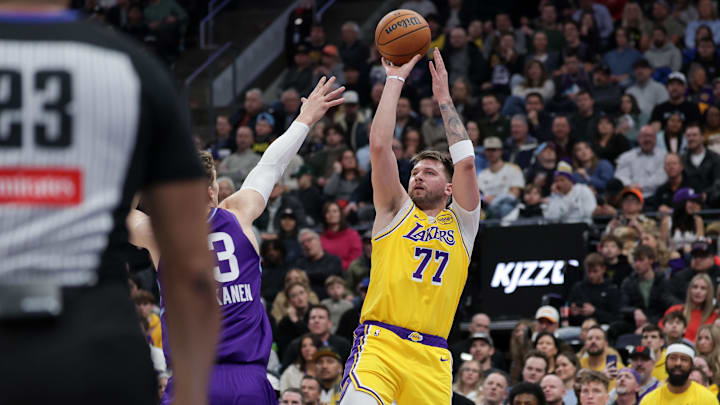 Feb 12, 2025; Salt Lake City, Utah, USA;  Los Angeles Lakers guard Luka Doncic (77) shoots over Utah Jazz forward Lauri Markkanen (23) during the second quarter at Delta Center. Mandatory Credit: Chris Nicoll-Imagn Images