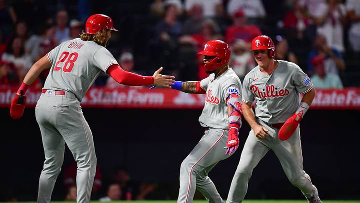 Philadelphia Phillies left fielder Edmundo Sosa (33) is greeted by catcher J.T. Realmuto (10) and third baseman Alec Bohm (28).