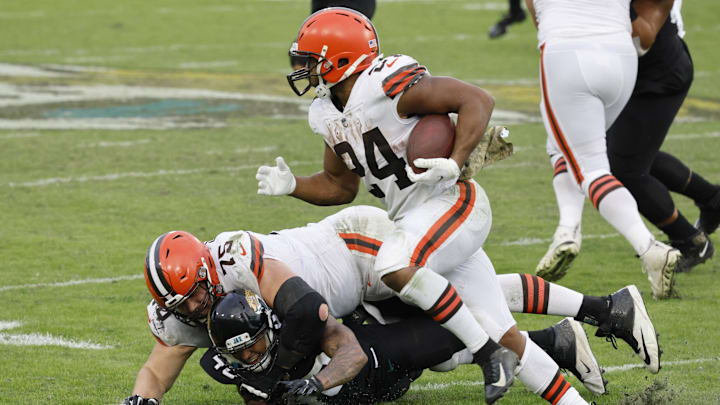 Nov 29, 2020; Jacksonville, Florida, USA;  Cleveland Browns offensive guard Joel Bitonio (75) lands on Jacksonville Jaguars cornerback Brandon Watson (40) as  Browns running back Nick Chubb (24) runs the ball during the second half at TIAA Bank Field. Mandatory Credit: Reinhold Matay-Imagn Images