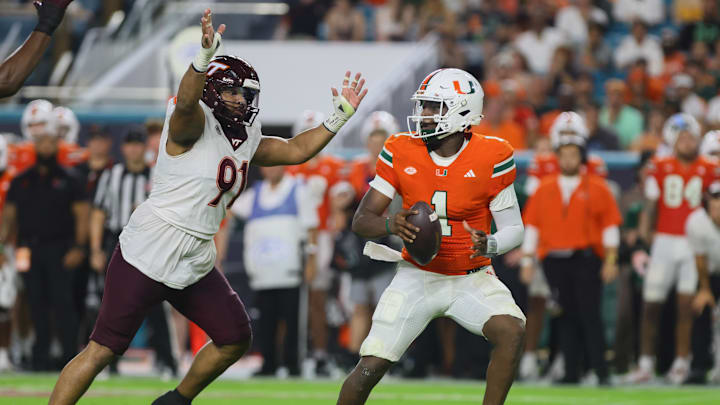 Sep 27, 2024; Miami Gardens, Florida, USA; Miami Hurricanes quarterback Cam Ward (1) drops back as Virginia Tech Hokies defensive lineman Wilfried Pene (91) defends during the second quarter at Hard Rock Stadium. Mandatory Credit: Sam Navarro-Imagn Images