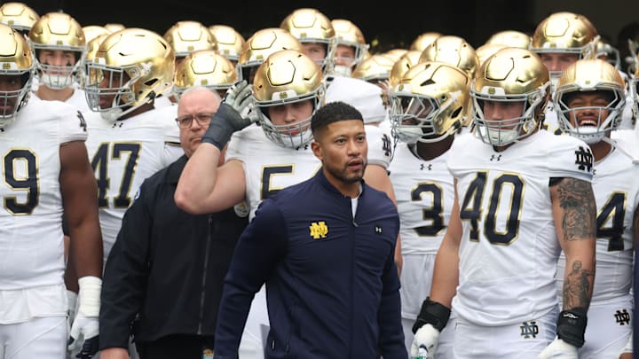 Nov 15, 2025; Pittsburgh, Pennsylvania, USA;  Notre Dame Fighting Irish head coach Marcus Freeman (middle) leads the team onto the field to play the Pittsburgh Panthers at Acrisure Stadium. Mandatory Credit: Charles LeClaire-Imagn Images