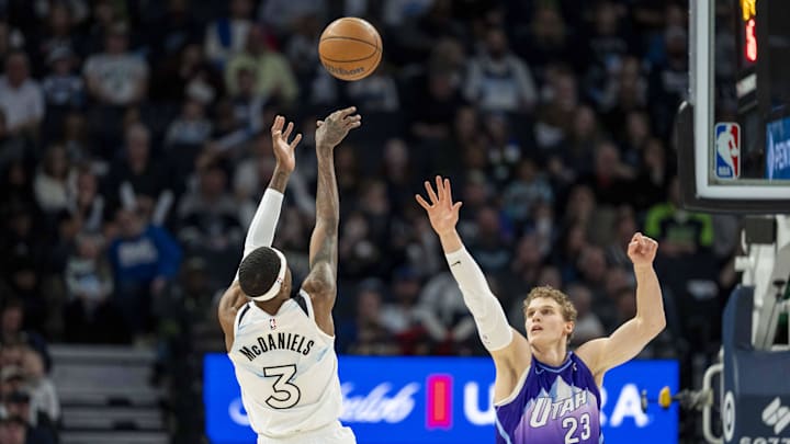 Mar 16, 2025; Minneapolis, Minnesota, USA; Minnesota Timberwolves forward Jaden McDaniels (3) shoots the ball over Utah Jazz forward Lauri Markkanen (23) in the second half at Target Center. Mandatory Credit: Jesse Johnson-Imagn Images