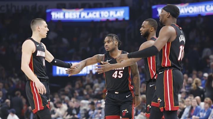 The Miami Heat's Tyler Herro (left), Davion Mitchell (45), Andrew Wiggins (center right) and Bam Adebayo (right).