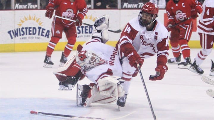 Wisconsin's Joe Palodichuk (14) collides with Badgers goaltender Daniel Hauser as Hauser attempts to make a save in the second period Wednesday March 11, 2026 at the Kohl Center in Madison, Wis. Ohio State scored on the play to take a 3-0 lead.