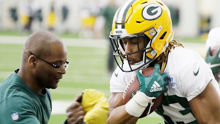 Green Bay Packers running backs coach Ben Sirmans works with RB Aaron Jones.