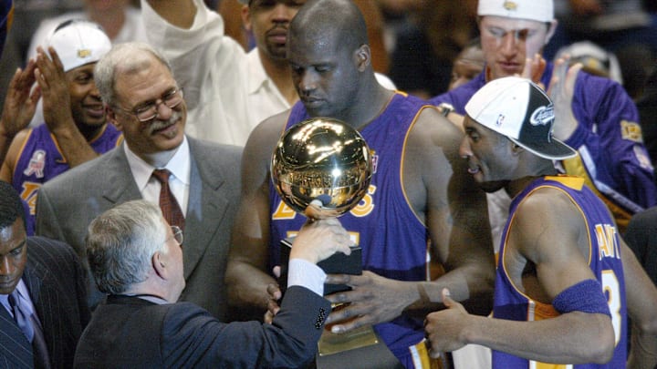 NBA commissioner David Stern hands Los Angeles Lakers Phil Jackson (left),  Shaquille O'Neal (center) and Kobe Bryant (right) their championship trophy at the end of Game 4 of the NBA Finals at The Meadowlands in 2002.