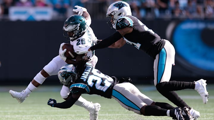 Oct 10, 2021; Charlotte, North Carolina, USA; Philadelphia Eagles running back Miles Sanders (26) runs with the ball as Carolina Panthers cornerback Donte Jackson (26) and safety Jeremy Chinn (21) defend during the second half at Bank of America Stadium.