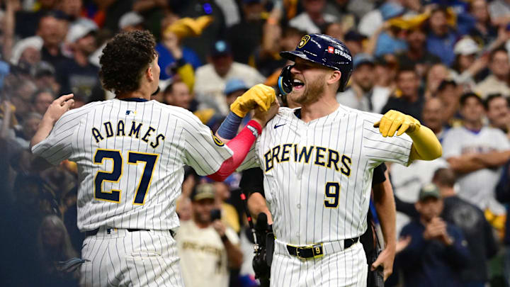 Oct 3, 2024; Milwaukee, Wisconsin, USA; Milwaukee Brewers pinch hitter Jake Bauers (9) celebrates with shortstop Willy Adames (27) after scoring a solo home run against the New York Mets in the seventh inning during game three of the Wildcard round for the 2024 MLB Playoffs at American Family Field. Mandatory Credit: Benny Sieu-Imagn Images