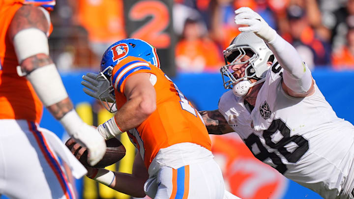 Oct 6, 2024; Denver, Colorado, USA; Las Vegas Raiders defensive end Maxx Crosby (98) leaps at Denver Broncos quarterback Bo Nix (10) for a sack in the second half at Empower Field at Mile High. Mandatory Credit: Ron Chenoy-Imagn Images