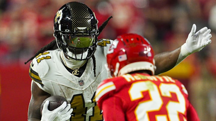 Oct 7, 2024; Kansas City, Missouri, USA; New Orleans Saints running back Alvin Kamara (41) runs the ball against Kansas City Chiefs cornerback Trent McDuffie (22) during the second half at GEHA Field at Arrowhead Stadium. Mandatory Credit: Jay Biggerstaff-Imagn Images