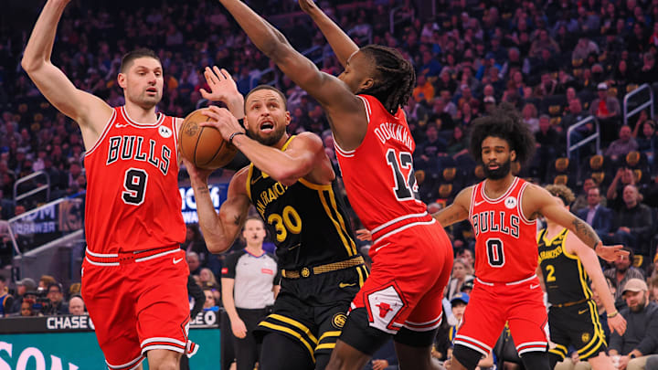 Mar 7, 2024; San Francisco, California, USA; Golden State Warriors guard Stephen Curry (30) drives between Chicago Bulls center Nikola Vucevic (9) and guard Ayo Dosunmu (12) during the first quarter at Chase Center. Mandatory Credit: Kelley L Cox-Imagn Images