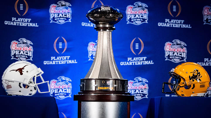 The Peach Bowl trophy is displayed next to the Texas Longhorns and Arizona State Sun Devils helmets during the Joint Head Coaches Press Conference at the Westin Peachtree Plaza in Atlanta, Georgia on Dec. 31, 2024, ahead of the Peach Bowl College Football Quarterfinal Game on New Years Day. Texas Longhorns Head Coach Steve Sarkisian joined Arizona Sun Devils Head Coach Kenny Dillingham at the press conference.