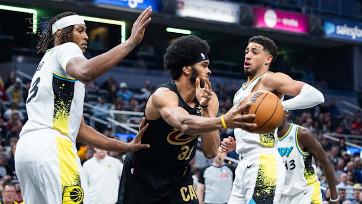 Apr 10, 2025; Indianapolis, Indiana, USA; Cleveland Cavaliers center Jarrett Allen (31) passes the ball while Indiana Pacers guard Tyrese Haliburton (0) defends in the first half at Gainbridge Fieldhouse. Mandatory Credit: Trevor Ruszkowski-Imagn Images