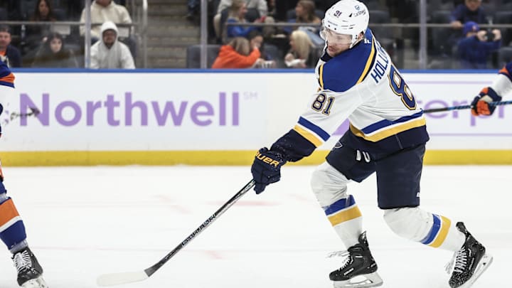 Nov 23, 2024; Elmont, New York, USA;  St. Louis Blues center Dylan Holloway (81) attempts a shot on goal in the third period against the New York Islanders at UBS Arena. Mandatory Credit: Wendell Cruz-Imagn Images