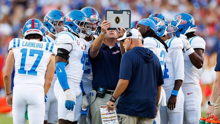 Sep 26, 2026; Gainesville, Florida, USA; Mississippi Rebels assistant special teams coach Chris Norris reviews a play with tight end Caleb Odom (4), kicker Lucas Carneiro (17), running back JT Lindsey (26) and teammates against the Florida Gators during the second half at Ben Hill Griffin Stadium. Mandatory Credit: Matt Pendleton-Imagn Images Sep 26, 2026; Gainesville, Florida, USA; Mississippi Rebels assistant special teams coach Chris Norris reviews a play with tight end Caleb Odom (4), kicker Lucas Carneiro (17), running back JT Lindsey (26) and teammates against the Florida Gators during the second half at Ben Hill Griffin Stadium. Mandatory Credit: Matt Pendleton-Imagn Images