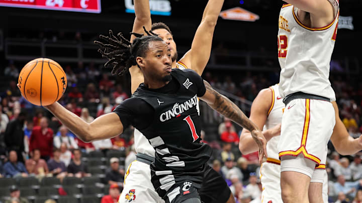 Mar 12, 2025; Kansas City, MO, USA; Cincinnati Bearcats guard Day Day Thomas (1) passes the ball around Iowa State Cyclones forward Milan Momcilovic (22) during the second half at T-Mobile Center. Mandatory Credit: William Purnell-Imagn Images