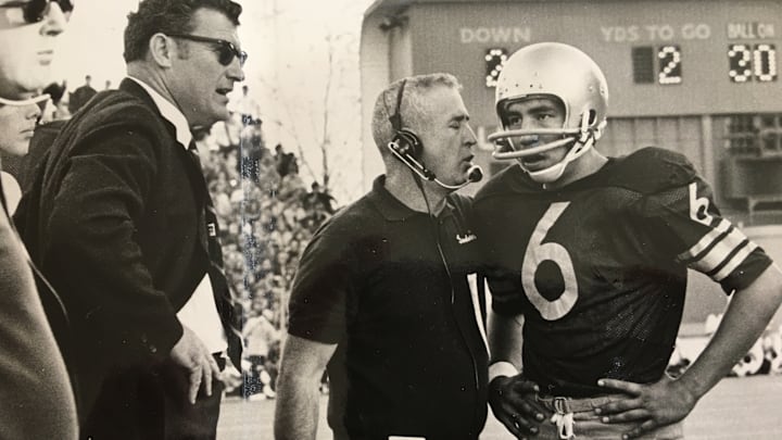 Sonny Sixkiller meets with assistant coach John Goodwin while coach Jim Owens looks on. 